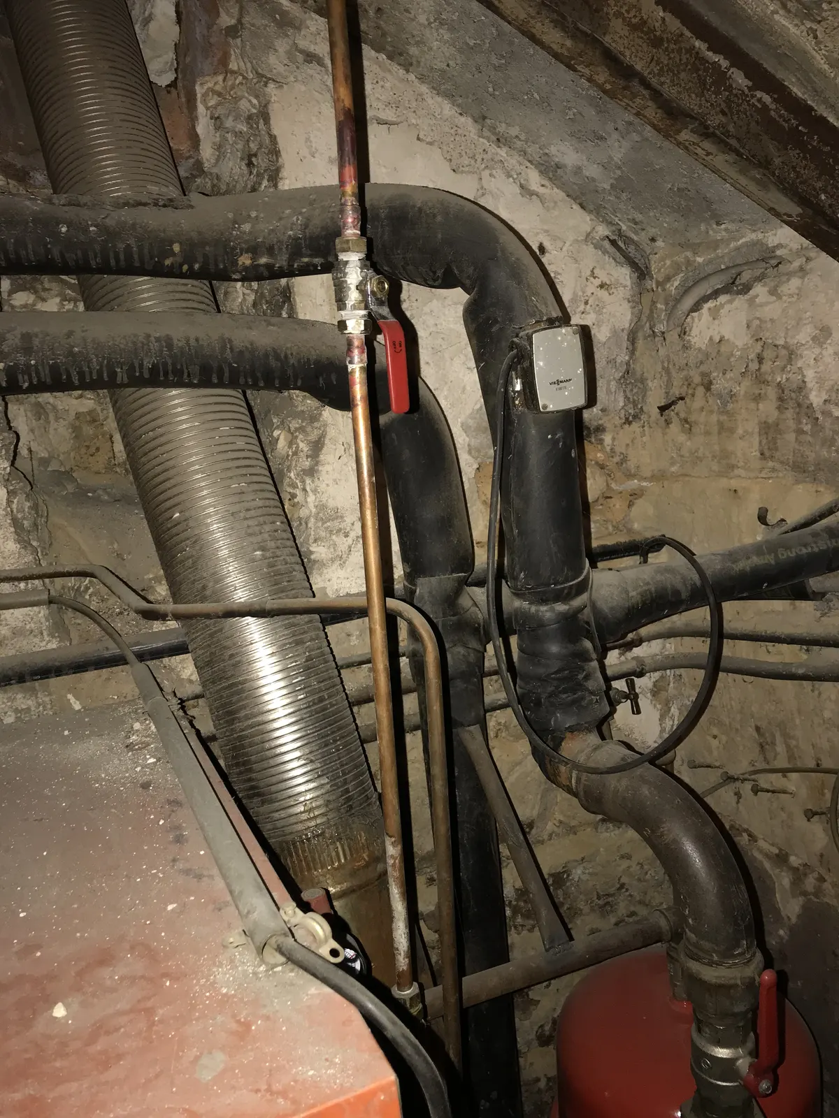 Réseaux hydrauliques et conduits calorifugés en chaufferie de cave