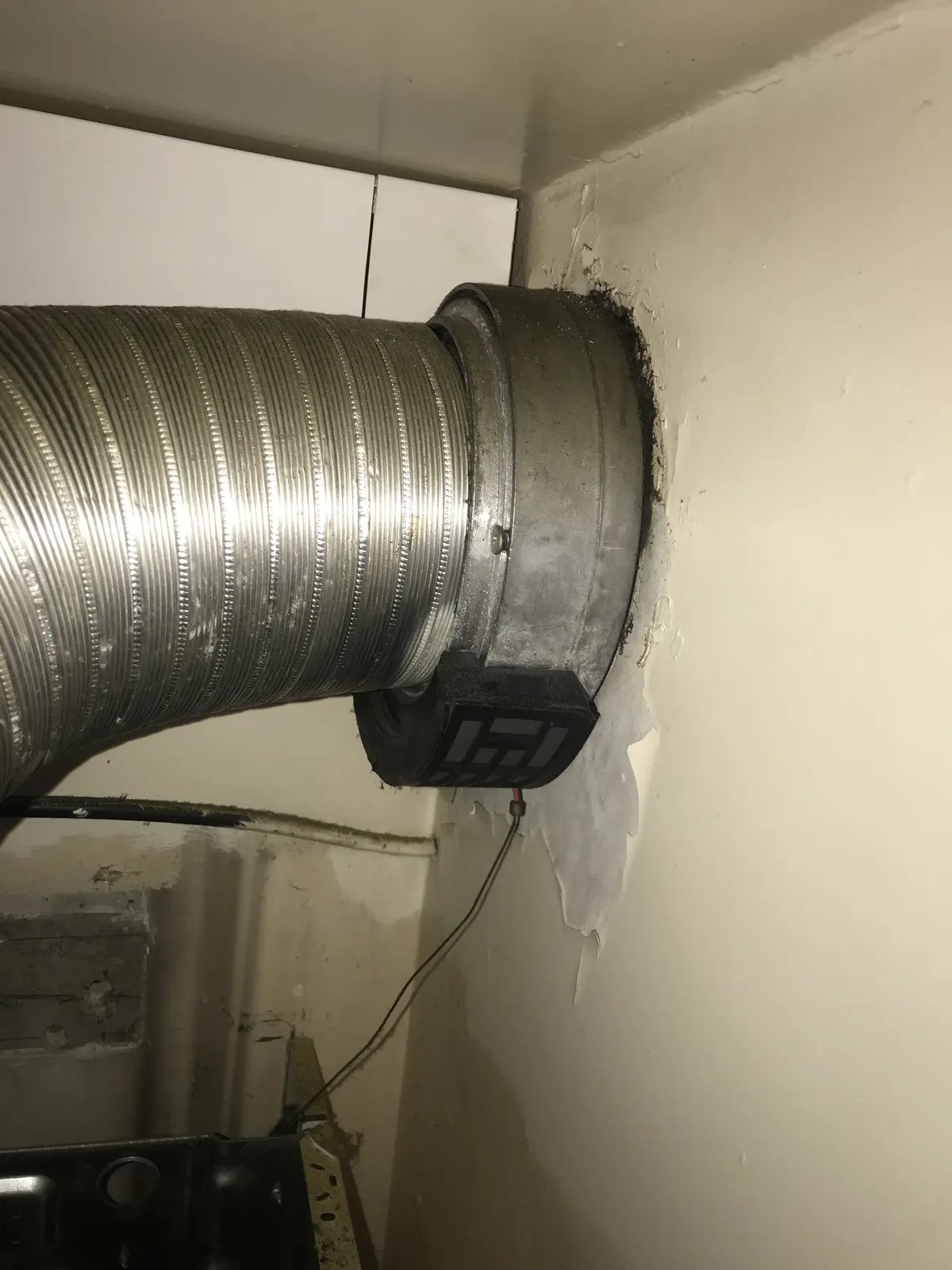 Raccordement d'un conduit de fumée flexible en traversée de mur