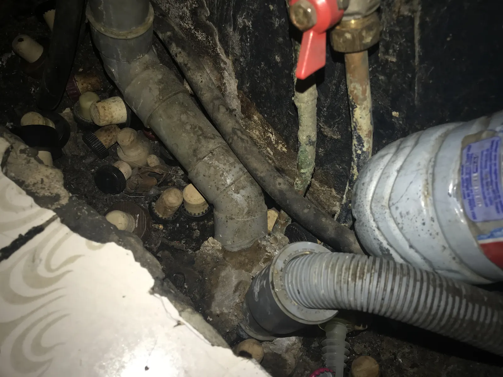 Canalisations anciennes corrodées inspectées lors d'un dépannage de plomberie